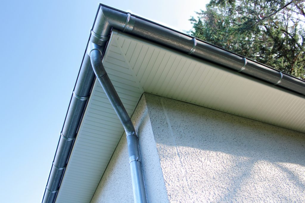 Gouttière zinc gris sur la façade de la maison, descentes et lambris de sous-face en PVC blanc